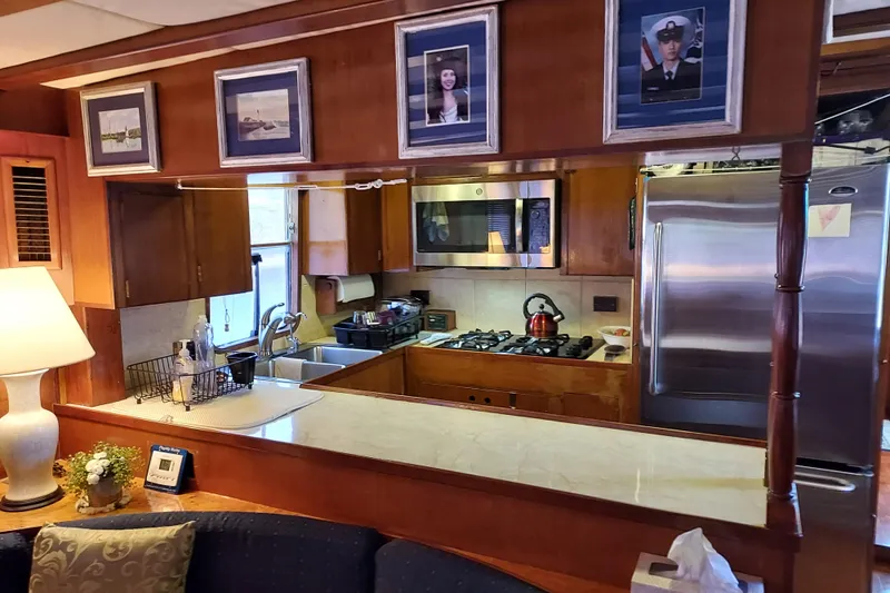 Noelani Yacht Photos Pics Interior of 1982 DeFever 52 Offshore Cruiser with kitchen and framed photos.
