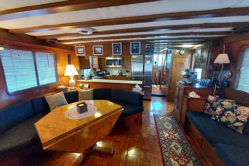 Noelani Yacht Photos Pics Interior of 1982 DeFever 52 Offshore Cruiser with cozy seating and wooden decor.