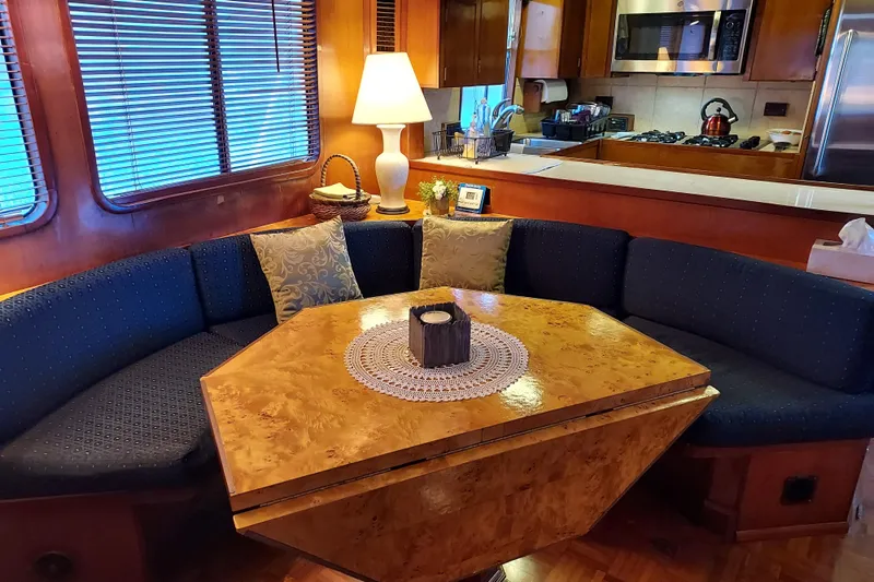 Noelani Yacht Photos Pics Interior of 1982 DeFever 52 Offshore Cruiser with cozy dining area and kitchen.