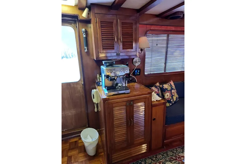 Noelani Yacht Photos Pics Interior of 1982 DeFever 52 Offshore Cruiser with coffee maker and wooden cabinetry.