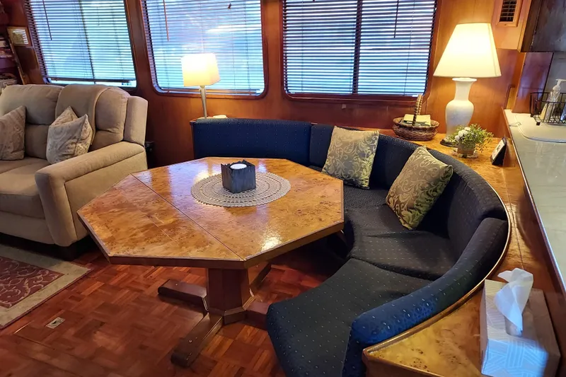 Noelani Yacht Photos Pics Interior of 1982 DeFever 52 Offshore Cruiser with cozy seating and wooden table.