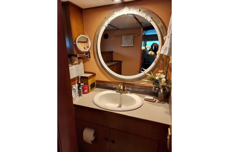 Noelani Yacht Photos Pics Elegant bathroom vanity on 1982 DeFever 52 Offshore Cruiser with round mirror and floral decor.