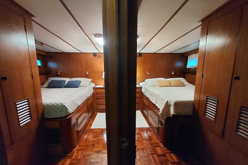 Noelani Yacht Photos Pics Luxurious 1982 DeFever 52 Offshore Cruiser cabin with twin beds and elegant wood finish.