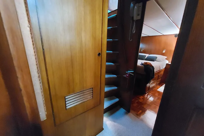 Noelani Yacht Photos Pics Interior of 1982 DeFever 52 Offshore Cruiser with wooden stairs and cozy bedroom.
