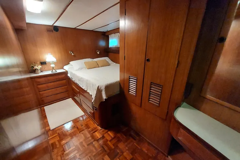 Noelani Yacht Photos Pics Cozy bedroom in 1982 DeFever 52 Offshore Cruiser with wood paneling and double bed.