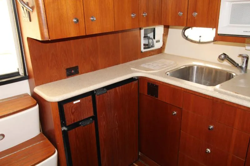  Yacht Photos Pics 2001 Tiara Yachts 3800 Open kitchen with wood cabinets and stainless steel sink.
