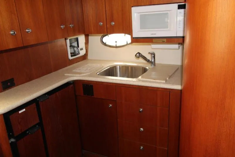  Yacht Photos Pics 2001 Tiara Yachts 3800 Open kitchen with wood cabinets, sink, and microwave.