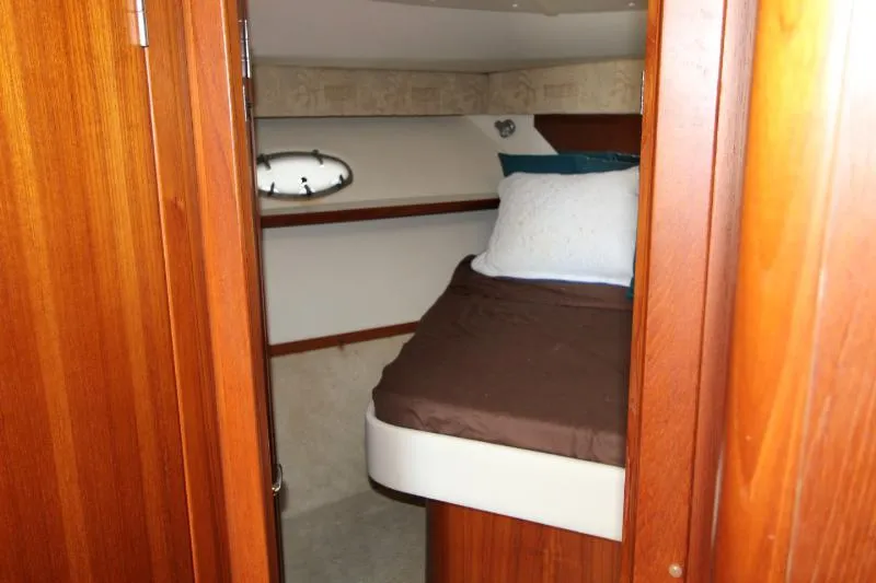  Yacht Photos Pics Cozy cabin interior of 2001 Tiara Yachts 3800 Open with wooden finish and bed.