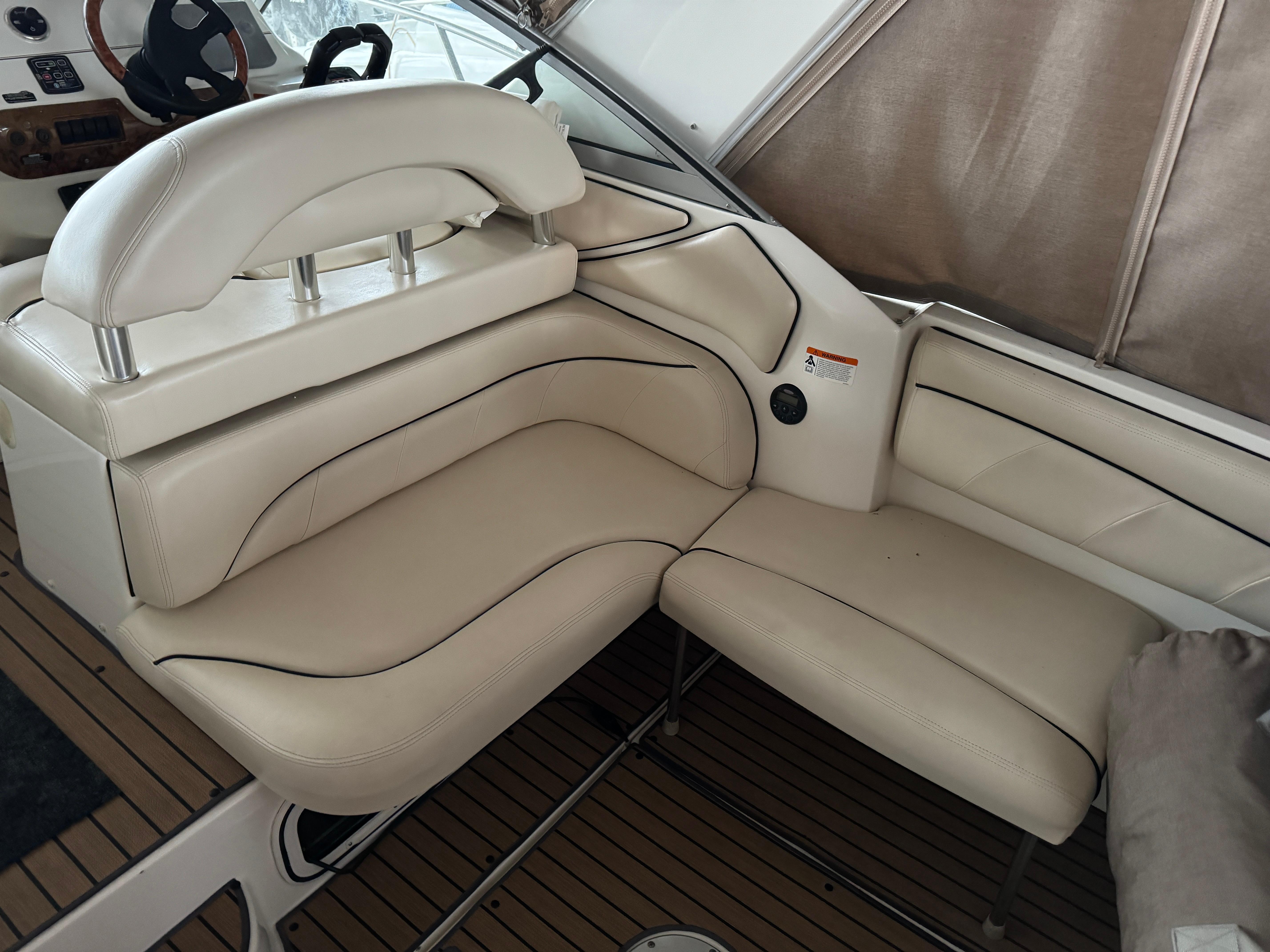 2003 Larson 330 Cabrio boat interior with beige leather seating and wood flooring.