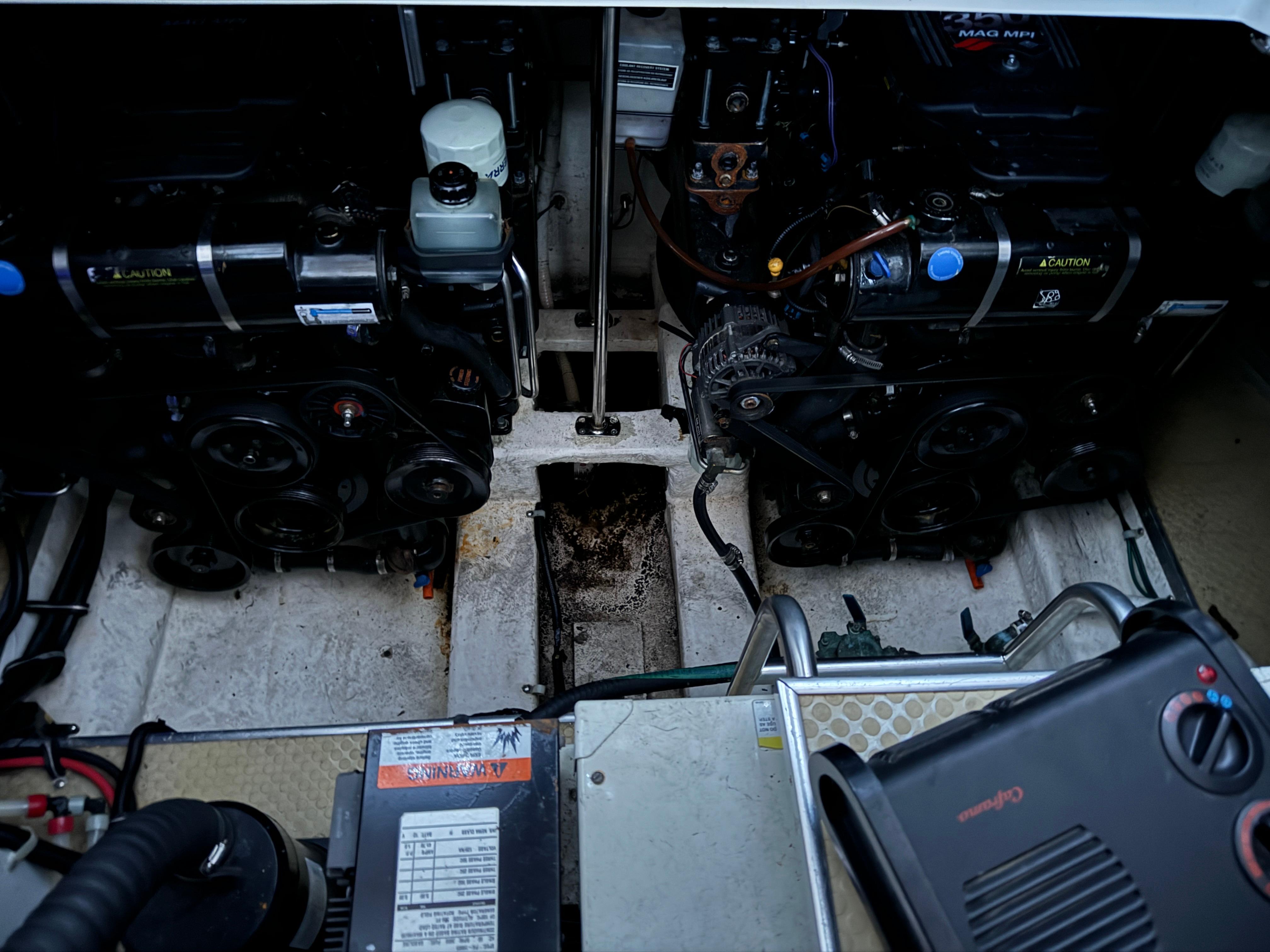 Engine compartment of a 2003 Larson 330 CABRIO boat, featuring dual engines and mechanical components.