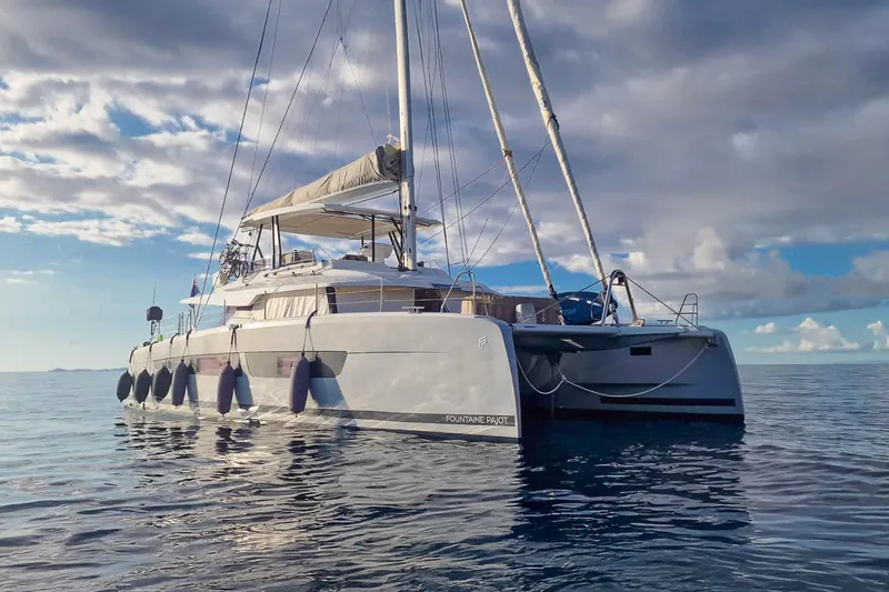  Yacht Photos Pics 2022 Fountaine Pajot Samana 59 catamaran sailing on calm ocean waters.