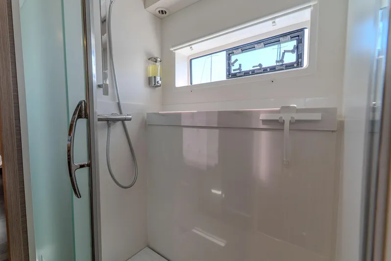  Yacht Photos Pics Modern shower area in 2022 Fountaine Pajot Samana 59 yacht, featuring sleek design and window.
