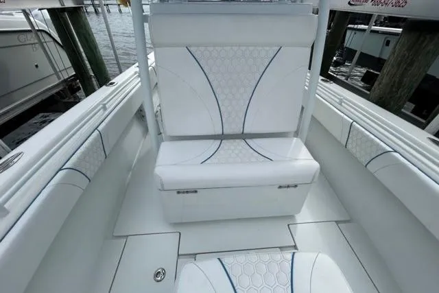  Yacht Photos Pics 2023 Contender 28 Tournament boat interior with white cushioned seating and hexagonal pattern.
