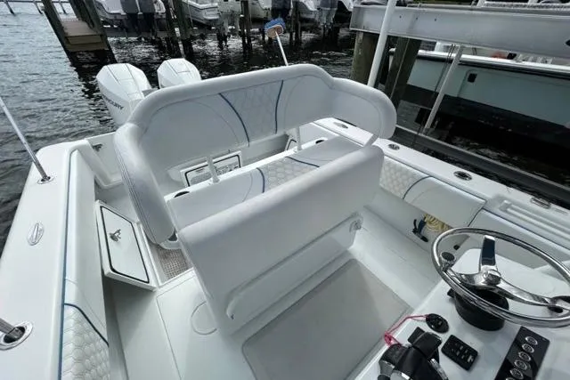  Yacht Photos Pics 2023 Contender 28 Tournament boat interior with helm, seating, and dual engines at dock.