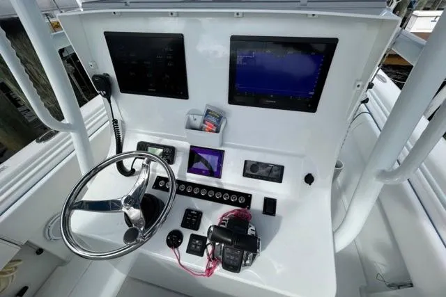  Yacht Photos Pics 2023 Contender 28 Tournament boat dashboard with steering wheel, controls, and dual screens.