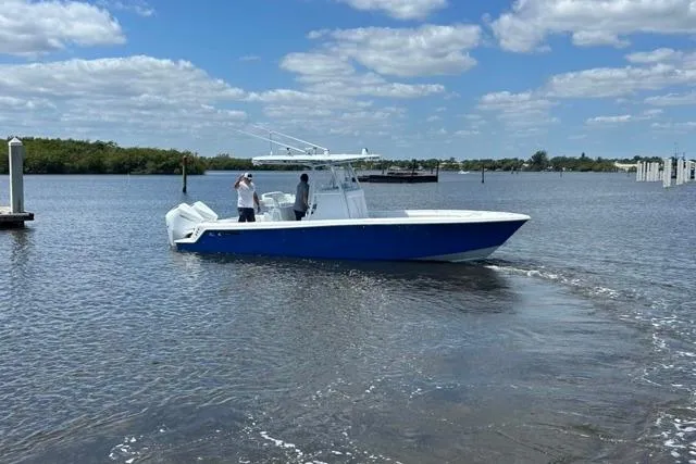  Yacht Photos Pics 2023 Contender 28 Tournament boat on calm water under a partly cloudy sky.