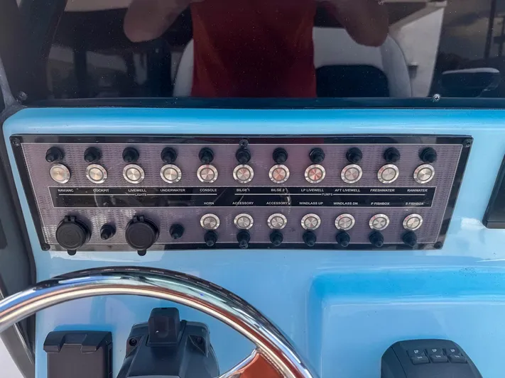  Yacht Photos Pics Control panel of 2024 Tidewater 256 Adventurer boat with labeled switches and steering wheel.