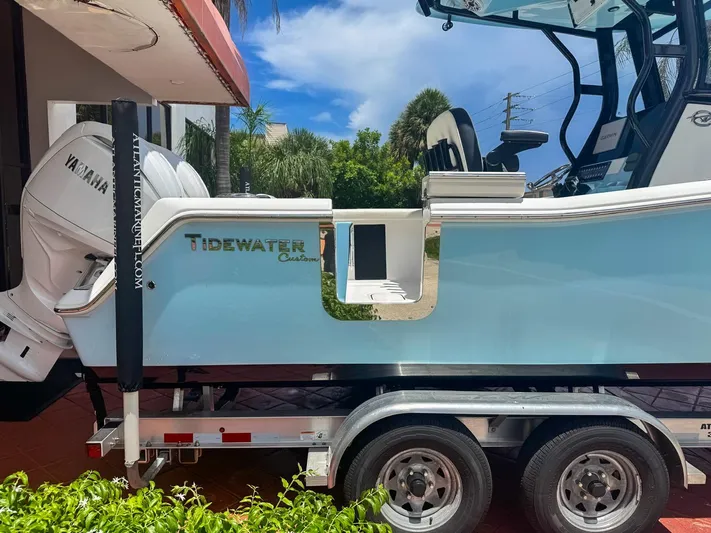  Yacht Photos Pics 2024 Tidewater 256 Adventurer boat on trailer, featuring Yamaha engine, parked outdoors.