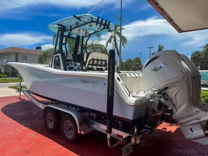  Yacht Photos Pics 2024 Tidewater 256 Adventurer boat on trailer, featuring Yamaha engine, parked outdoors.