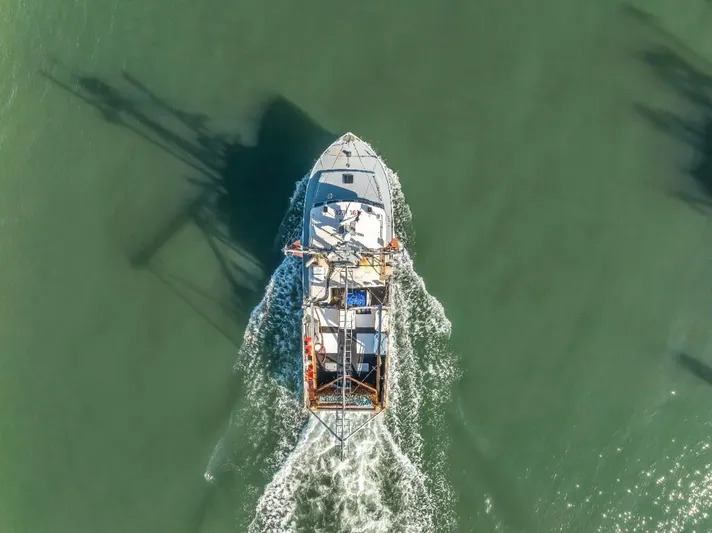  Yacht Photos Pics Aerial view of 2015 Wesmac commercial fishing vessel navigating through green waters.