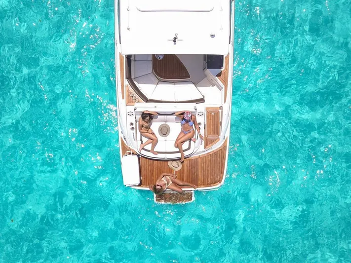  Yacht Photos Pics 2017 Sea Ray 350 SLX yacht on clear turquoise water, with people sunbathing on deck.