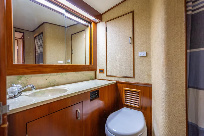 Andiamo Yacht Photos Pics 1979 Merritt 46 yacht bathroom with wood accents and modern fixtures.