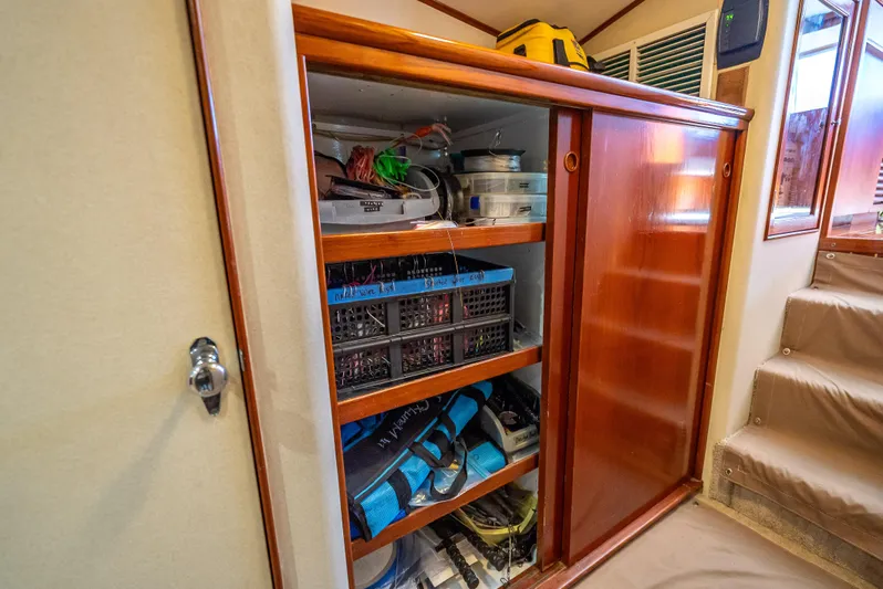 Andiamo Yacht Photos Pics Wooden storage cabinet with organized shelves on a 1979 Merritt 46 boat.