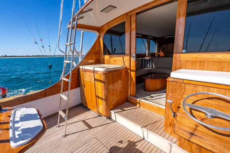 Andiamo Yacht Photos Pics 1979 Merritt 46 yacht interior with wooden finish, ocean view, and seating area.