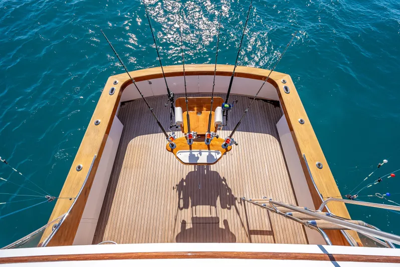 Andiamo Yacht Photos Pics Fishing deck of 1979 Merritt 46 yacht with rods, overlooking blue ocean water.