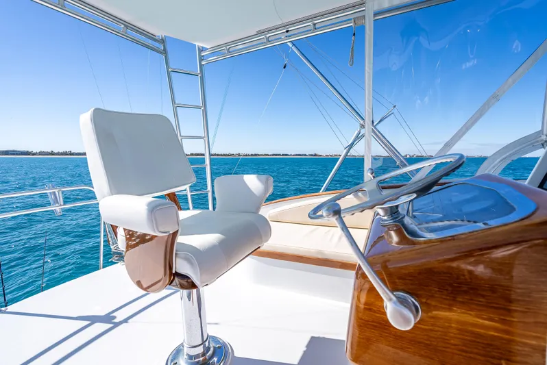 Andiamo Yacht Photos Pics Luxury yacht helm with white captain's chair, Merritt 46, 1979 model, on open sea.