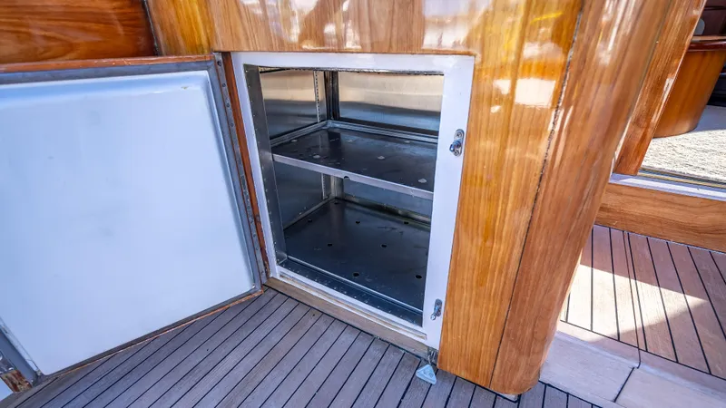 Andiamo Yacht Photos Pics Open stainless steel storage compartment on 1979 Merritt 46 yacht with wooden interior.