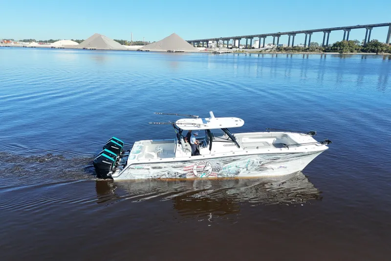  Yacht Photos Pics 2024 Front Runner 37 Catamaran cruising on calm waters near a bridge.