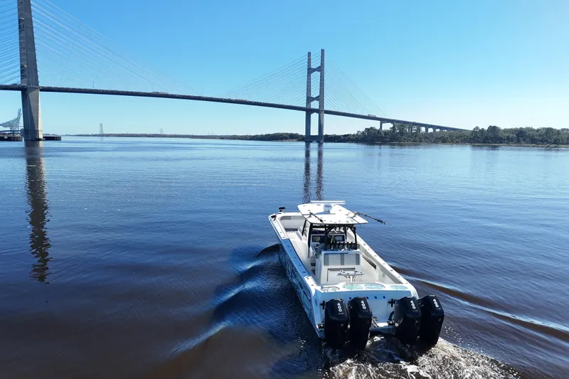  Yacht Photos Pics 2024 Front Runner 37 Catamaran cruising under a large bridge on a sunny day.