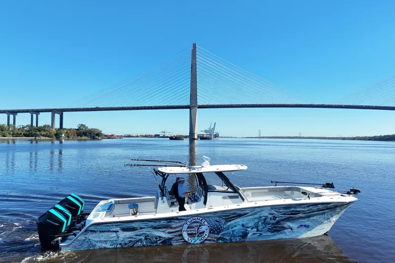  Yacht Photos Pics 2024 Front Runner 37 Catamaran cruising under a large bridge on a sunny day.
