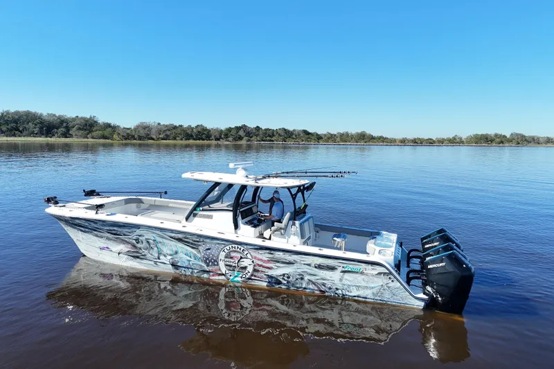  Yacht Photos Pics 2024 Front Runner 37 Catamaran on calm water, featuring vibrant graphics and powerful outboard engines.