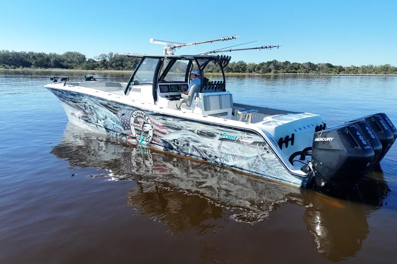  Yacht Photos Pics 2024 Front Runner 37 Catamaran with vibrant graphics and Mercury engines on calm water.
