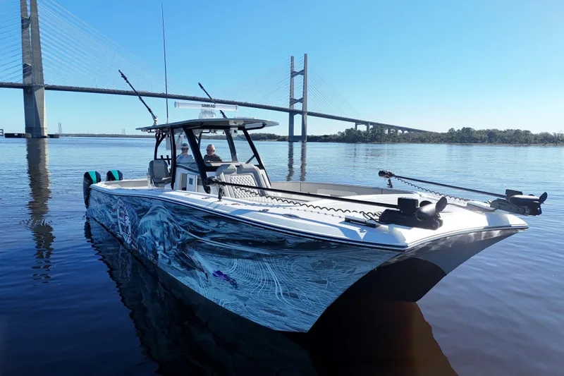 Yacht Photos Pics 2024 Front Runner 37 Catamaran on calm water near a bridge, showcasing sleek design.
