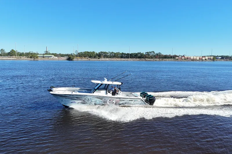  Yacht Photos Pics 2024 Front Runner 37 Catamaran cruising on a sunny day, creating waves in the water.