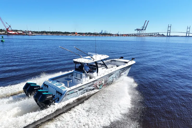  Yacht Photos Pics 2024 Front Runner 37 Catamaran cruising on a sunny day near a bridge and port.