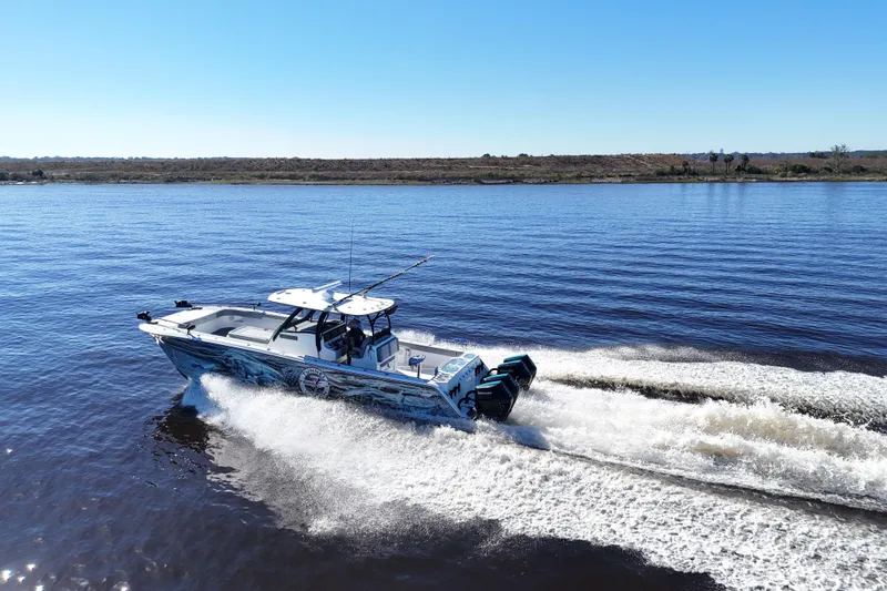  Yacht Photos Pics 2024 Front Runner 37 Catamaran cruising on a calm lake under clear blue skies.