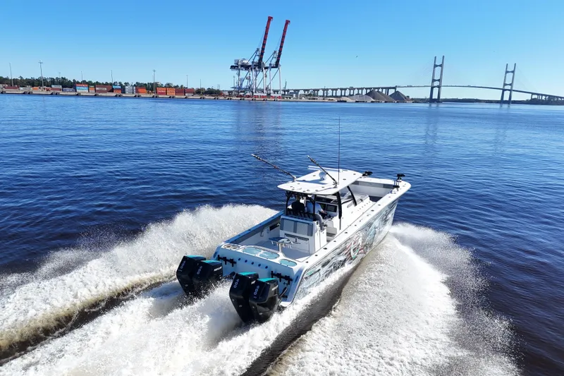  Yacht Photos Pics 2024 Front Runner 37 Catamaran cruising on water near a bridge and industrial port.
