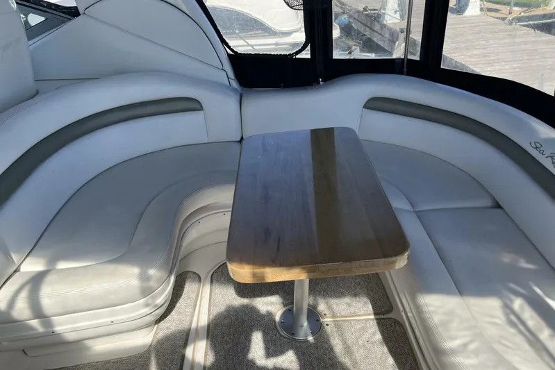  Yacht Photos Pics Interior of 2007 Sea Ray 340 Sundancer with curved seating and wooden table.