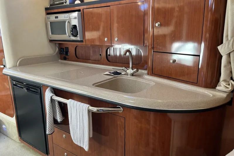  Yacht Photos Pics 2007 Sea Ray 340 Sundancer kitchen with wood cabinets, sink, and microwave.