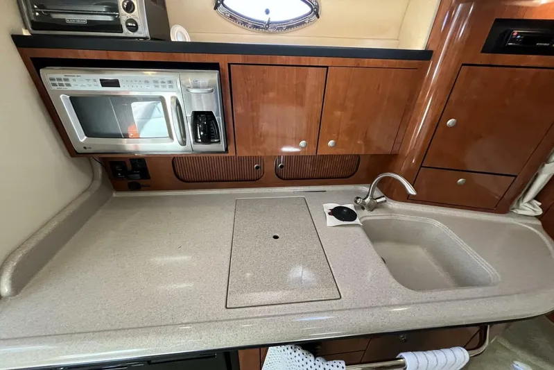 Yacht Photos Pics 2007 Sea Ray 340 Sundancer kitchen with microwave, sink, and wooden cabinetry.