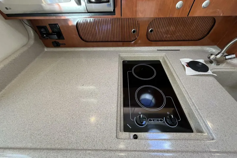  Yacht Photos Pics 2007 Sea Ray 340 Sundancer galley with electric cooktop and wooden cabinetry.