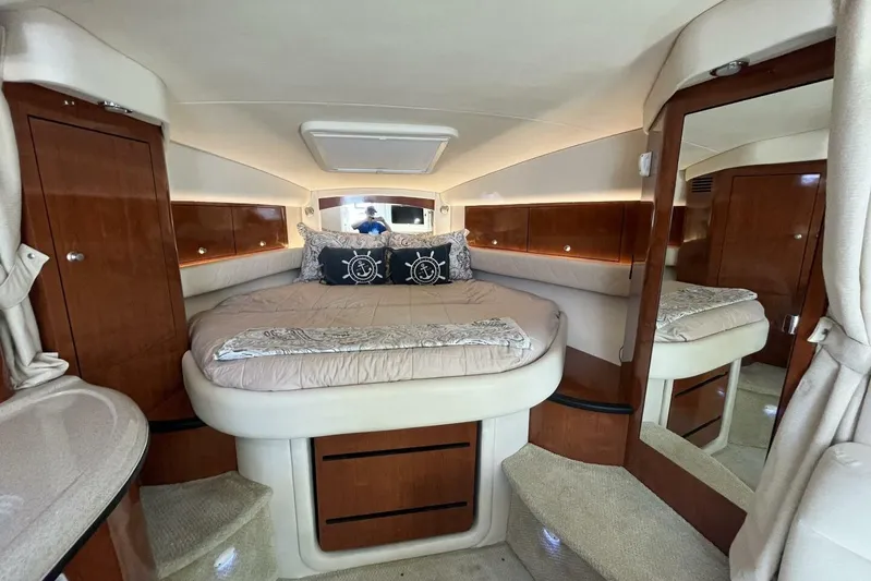  Yacht Photos Pics Luxurious cabin interior of 2007 Sea Ray 340 Sundancer yacht with cozy bed and wooden accents.