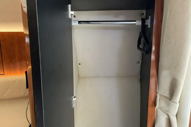  Yacht Photos Pics Empty closet inside 2007 Sea Ray 340 Sundancer yacht, featuring a hanging rod and wooden interior.
