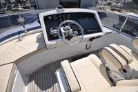 Helm of 2010 Trader 64 Sunliner yacht with modern controls and beige seating.