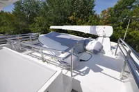 2010 Trader 64 Sunliner yacht deck with dinghy and crane, surrounded by trees.