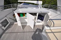 2010 Trader 64 Sunliner yacht deck with open storage compartments and seating.